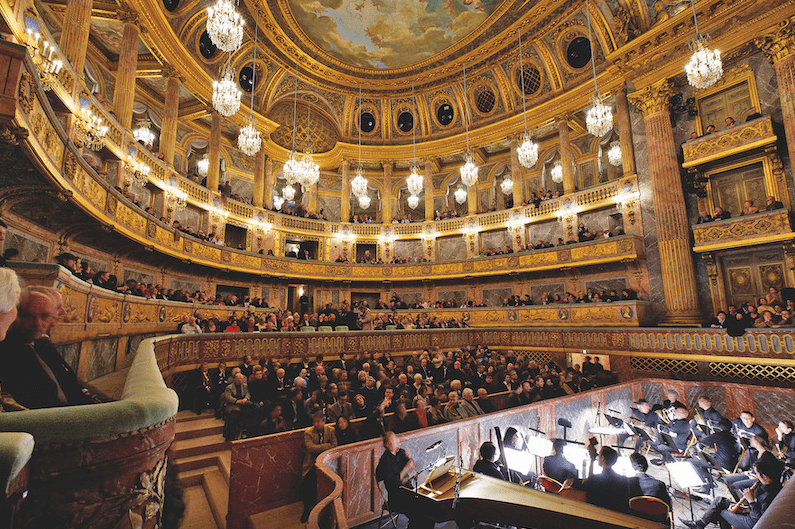 opera house in versailles people watching a concert with an orchestra