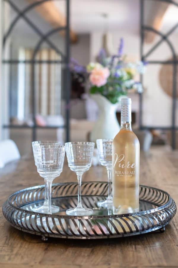 a bottle of Mirabeau wine with two glasses on a tray on a table