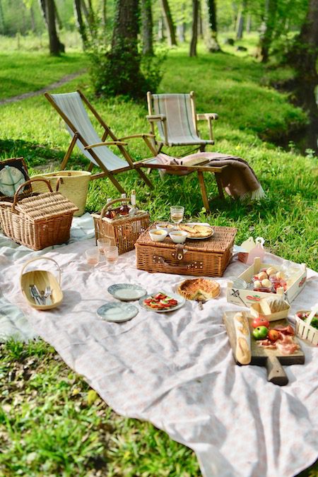 two deckchairs, picnic rug and food laid out on grass