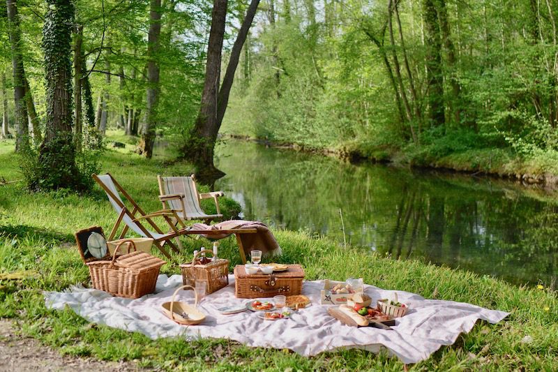 two deckchairs, picnic rug and food laid out on grass