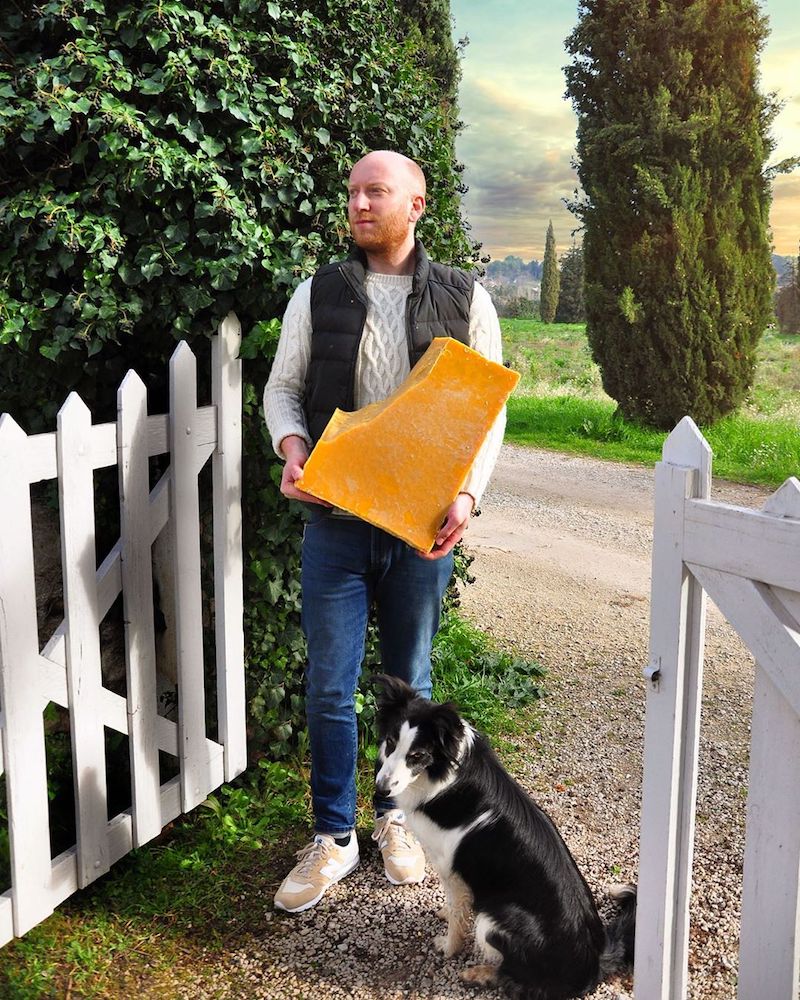 a man holding a chunk of beeswax with a dog
