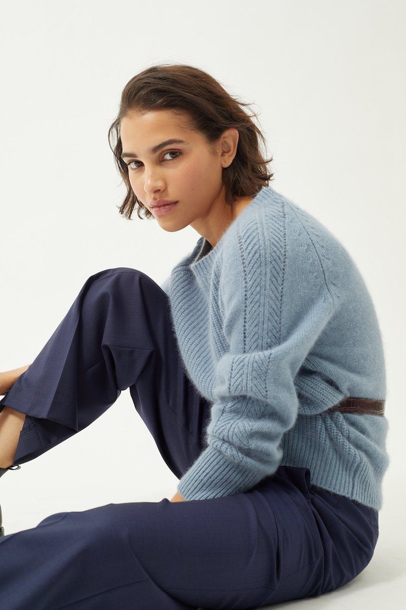 girl sitting in light blue sweater and blue trousers