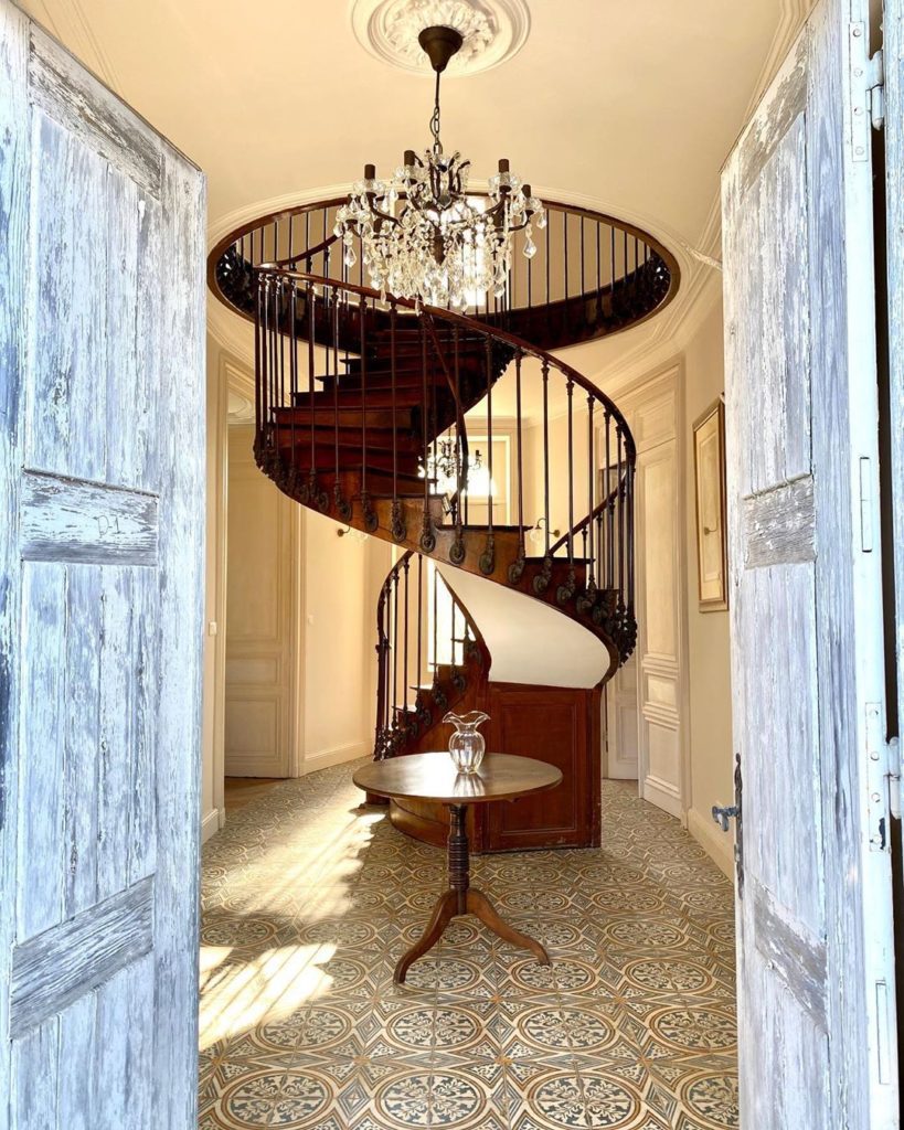 spiral staircase and chandelier as seen from doors of chateau