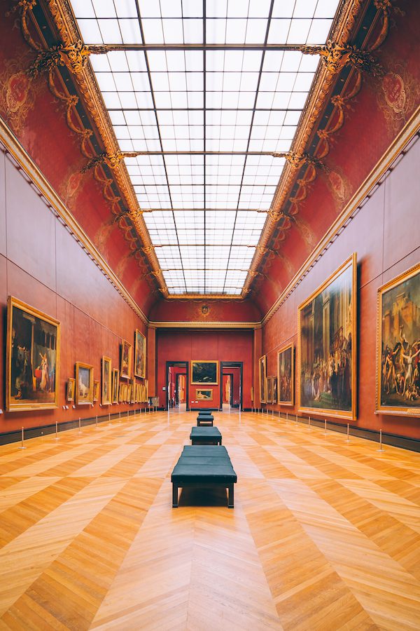 louvre hallways with red walls and paintings