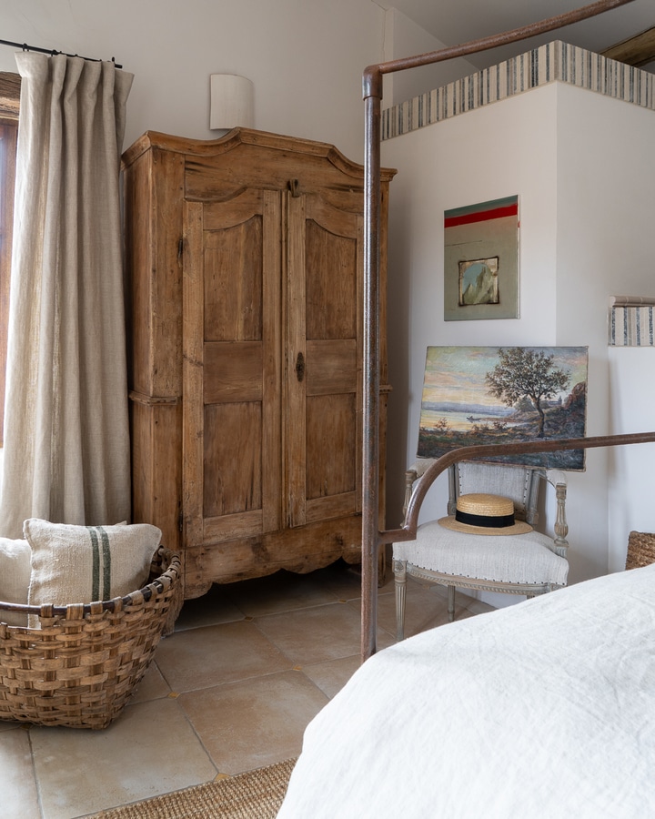 Wooden wardrobe and woven baskets in a country themed bedroom : MFCH French Bedroom Design Inspiration