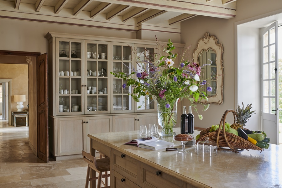 Beige cabinets in a kitchen with a large bouquet of flowers on display - French Kitchen Design Inspiration
