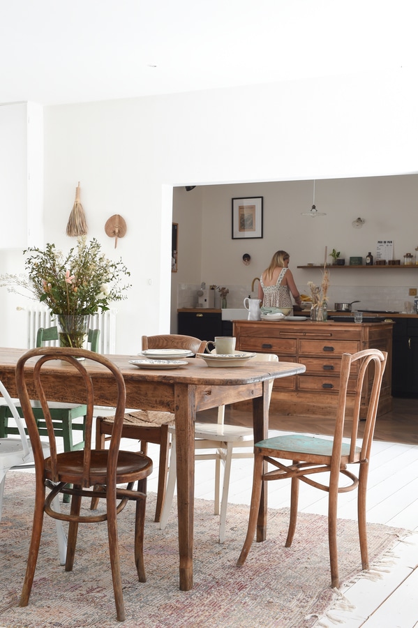 Rustic wooden table and chairs in a dining room overlooking a kitchen - French Kitchen Design Inspiration
