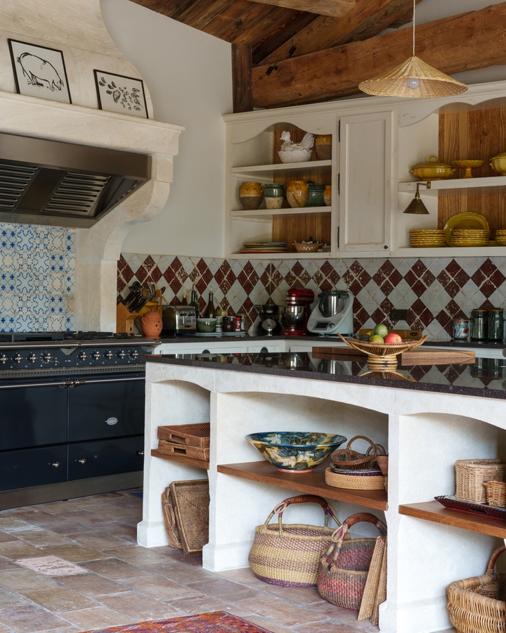 Provençal kitchen with white cabinets and patterned tiles and plate storage